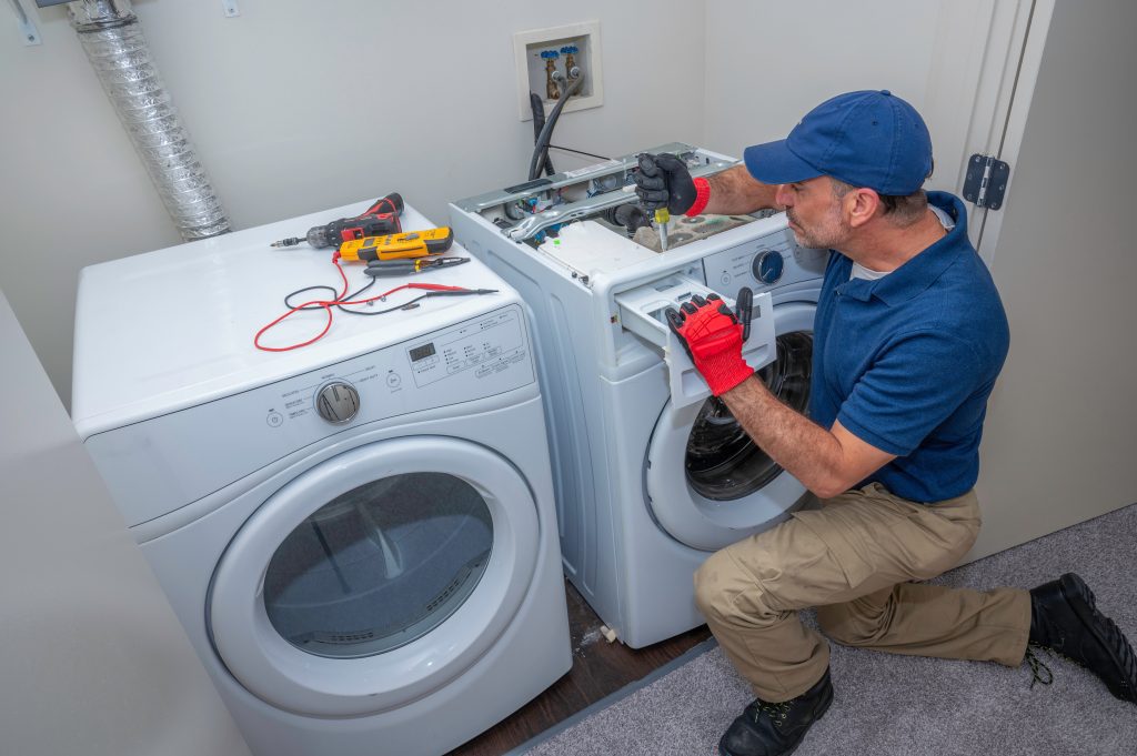 Appliance technician working on a front load washing machine in